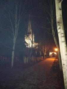 uma torre do relógio iluminada à noite num parque em Oakleigh house em Stratford-upon-Avon