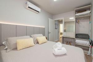 1 dormitorio con 1 cama blanca grande y 2 almohadas en Campos de Canela 402 - Stay House Temporada, en Canela