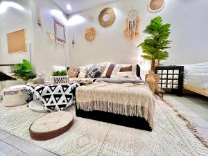 a bedroom with a bed and a couch with pillows at Boho lovely - بتسجيل وصول ذاتي in Riyadh