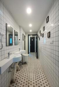 不负韶华青年旅馆 Youth Hostel في سوتشو: حمام ابيض ومغسلتين ومرحاض