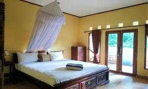 a bedroom with a bed with a canopy at Matahari Bungalow 3 in Gili Air