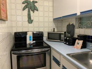サンファンにあるLuna Llena Beach 1Bdr Oceanview Poolのコンロと電子レンジ付きのキッチン