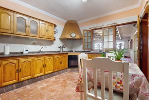 - une cuisine avec des placards en bois, un évier et une table dans l'établissement Casa Luna, à Icod de los Vinos