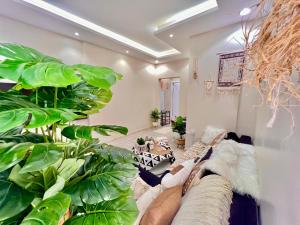 a living room with a couch and some plants at Boho lovely - بتسجيل وصول ذاتي in Riyadh