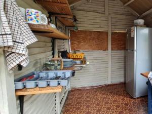 cocina con fregadero y nevera en Tsitsikamma Wolf Sanctuary ECO Cabins & Teepees, en Stormsriviermond