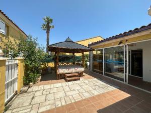 un gazebo con panchina sul patio di Village naturiste - Villa Le spa de la Palmeraie - 3 chambres - 100 m2 a Cap d'Agde