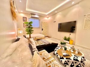 a living room with a couch and a tv at Boho lovely - بتسجيل وصول ذاتي in Riyadh