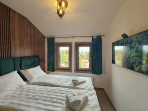 1 dormitorio con 2 camas y 2 ventanas en Velika Recepcija 48 en Zlatibor