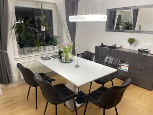 a white table and chairs in a room with a kitchen at Gemütliche 3 Zimmer Wohnung Ruben in Wolfenbüttel