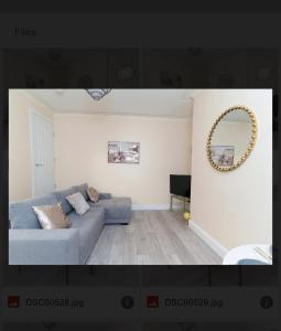 a living room with a couch and a mirror at St James House - Sleeps 8! in Leeds
