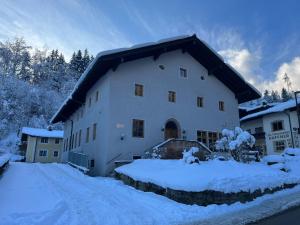 een groot wit gebouw met sneeuw op de grond bij Twenty Seven Budget Hotel in Zell am See