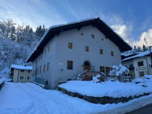 a large white building with snow on the ground at Twenty Seven Budget Hotel in Zell am See