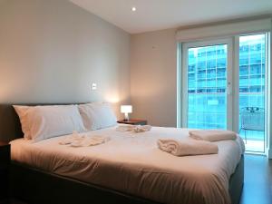 um quarto com uma cama grande e toalhas em Still Life Aldgate Deluxe em Londres