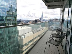 uma varanda com 2 cadeiras e vista para a cidade em Still Life Aldgate Deluxe em Londres