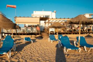 un gruppo di sedie e ombrelloni in spiaggia di By the sea a Faro