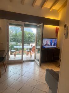 ein Wohnzimmer mit einer Glasschiebetür und einem TV in der Unterkunft Mimosas Cottage 2 Pièces eze bord de mer in Èze