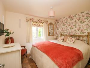 a bedroom with a bed and a window with flowers at Dragonfly Lodge in Shrewsbury
