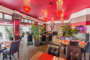 un restaurant avec des plafonds rouges, des tables et des chaises dans l'établissement Seashell Studios Mandurah, à Mandurah