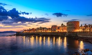 a view of a city at sunset with the water at Casa Vacanze Maiorca & Minorca in Alghero