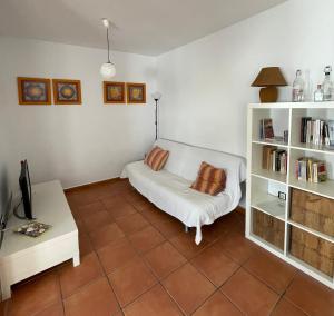 a living room with a white couch and book shelves at La Rosada 9 in Las Negras