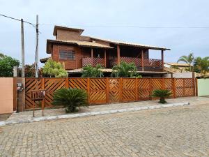 ein Haus mit einem Holzzaun davor in der Unterkunft Casa em Grussai 6 quartos e piscina Sâo Joâo da Barrra-RJ in São João da Barra