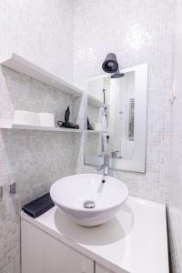 uma casa de banho branca com um lavatório e um espelho em Luxurious 1 Bedroom Republique Vinaigriers em Paris