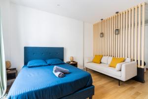 um quarto com uma cama azul e um sofá em Luxurious 1 Bedroom Republique Vinaigriers em Paris