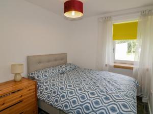 1 dormitorio con 1 cama, vestidor y ventana en Gun Powder Cottage, en Tighnabruaich