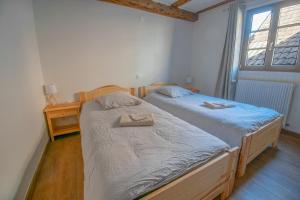 two twin beds in a room with a window at Duplex en ville vue château - Studio - Parking in Kaysersberg