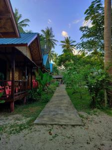 a path next to a building with palm trees at Kohmook Happy time Bungalow in Ko Mook