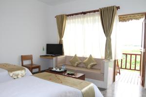 Mekong Riverside Boutique Resort & Spa tesisinde bir odada yatak veya yataklar