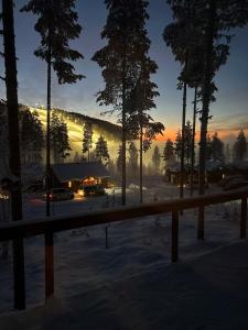 a view of a lodge in the snow at sunset at Stuga i Storklinten in Harads