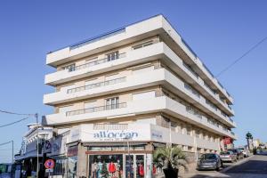 a tall white building on a street with a store at Vacances au pied de la plage du Val-André in Le Val-André +16 photos