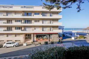 an apartment building with a car parked in front of it at Vacances au pied de la plage du Val-André in Le Val-André