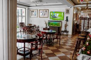 un restaurant avec des tables et des chaises et une télévision à écran plat dans l'établissement ROYAL PARK HOTEL AND CHINESE RESTAURANT, à Kumasi