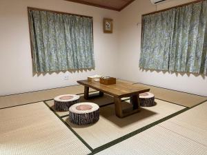 a room with a table and two stools at Guest House Kubo Homes Shotenshita in Osaka