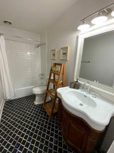ein Badezimmer mit einem Waschbecken, einem WC und einem Spiegel in der Unterkunft Vistamar Villa 5BDR Private Waterfront Home Pool 