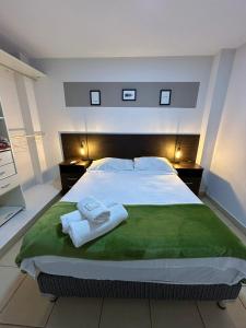 a bedroom with a large bed with towels on it at Apartamentos El Fortín in San Salvador de Jujuy