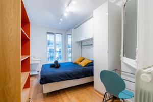 a small bedroom with a bed and a blue chair at Luxurious 1 Bedroom Tour Eiffel Saint Dominique Free Netflix in Paris