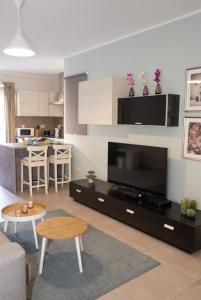 uma sala de estar com uma televisão de ecrã plano e uma cozinha em Comfort and Convenience flat 4 dad's court em St. Paul's Bay