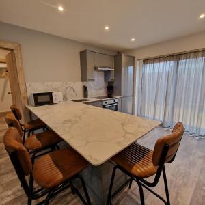 a kitchen with a large marble table and chairs at Brookside Cottages in Ingoldmells