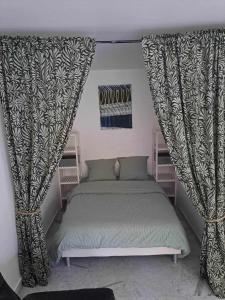 een slaapkamer met een bed en gordijnen in een kamer bij Appartement calme, cosy Piscine in Mandelieu-la-Napoule