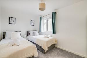 een slaapkamer met 2 bedden en een raam bij 3 bedroom detached house free car park close to town airport in Luton