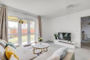 ein Wohnzimmer mit einem Sofa und einem Tisch in der Unterkunft 3 bedroom detached house free car park close to town airport in Luton