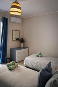 sypialnia z 2 łóżkami, komodą i lampą w obiekcie Lovely holiday home next to Bus terminus w mieście St Paul's Bay