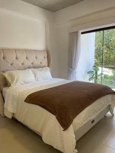 een slaapkamer met een groot bed en een groot raam bij Luxury Experience in Asunción: Fully Equipped in Asuncion