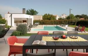 a patio with a table and chairs and a swimming pool at Villa Zen near Medulin for 8 people with wellness & sea view - only 1 km from beach in Vintijan