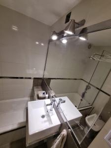 y baño con lavabo blanco y espejo. en El Depa Calle Rivadavia en Salta
