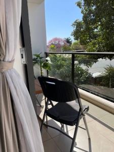 a black chair sitting on a balcony with a window at Luxury Experience in Asunción: Fully Equipped in Asunción