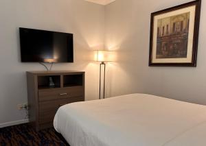 a hotel room with a bed and a flat screen tv at Baymont by Wyndham Indianapolis Northwest in Indianapolis